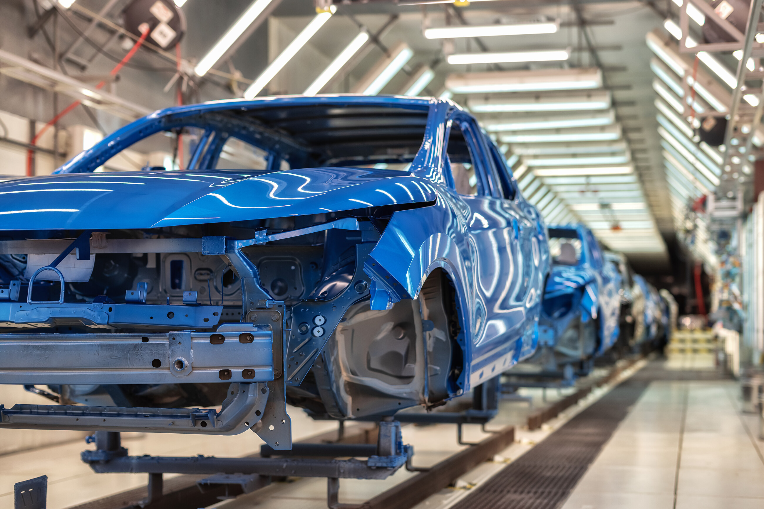Caisse de voiture bleue sur un convoyeur de ligne de production automobile